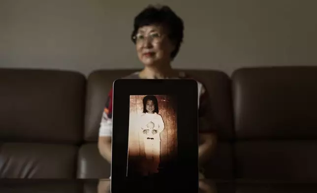 Han Tae-soon, sits for a photo with a computer tablet displaying an old photo of her daughter, at her home in Anyang, South Korea, Saturday, June 1, 2024. Han's daughter went missing and she searched for her for years, only to discover later she'd been adopted to the United States. (AP Photo/Jae C. Hong)