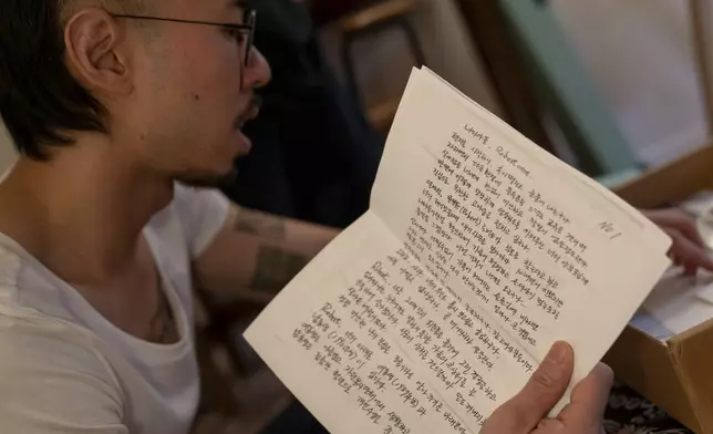 Robert Calabretta holds a letter written to him by his biological father while sifting through family mementos at his apartment, Thursday, Feb. 15, 2024, in New York. (AP Photo/David Goldman)