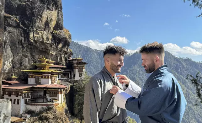 This 2024 photos shows Stefan Arestis, left, and Sebastien Chaneac at the Tiger’s Nest Monastery in Bhutan. The two have written a guide for LGBTQ+ Travelers, “Out in the World.” (The Nomadic Boys via AP)