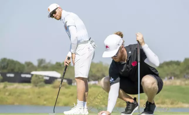 Scott Vincent, left, of Iron Heads GC, and Kieran Vincent, right, of Legion XIII, occupy the fifth green during the final round of LIV Golf Team Championship Dallas at Maridoe Golf Club, Sunday, Sept. 22, 2024, in Carrollton, Texas. (Charles Laberge/LIV Golf via AP)