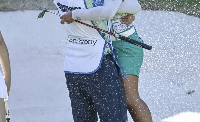 Jasmine Suwannapura, of Thailand, celebrates with her caddie and husband Mike Thomas after winning the LPGA Walmart NW Arkansas Championship golf tournament, Sunday, Sept. 29, 2024, in Rogers, Ark. (AP Photo/Michael Woods)