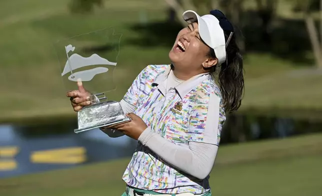 Jasmine Suwannapura, of Thailand, celebrates with her trophy after winning the LPGA Walmart NW Arkansas Championship golf tournament, Sunday, Sept. 29, 2024, in Rogers, Ark. (AP Photo/Michael Woods)