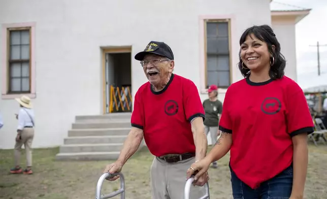 Alumni Lionel Salgado walks the Blackwell school grounds with help from his grand daughter Sarah Madero during its inauguration as the newest National Historic Site in Marfa, Texas, Saturday, Sept. 14, 2024. (AP Photo/Andres Leighton)