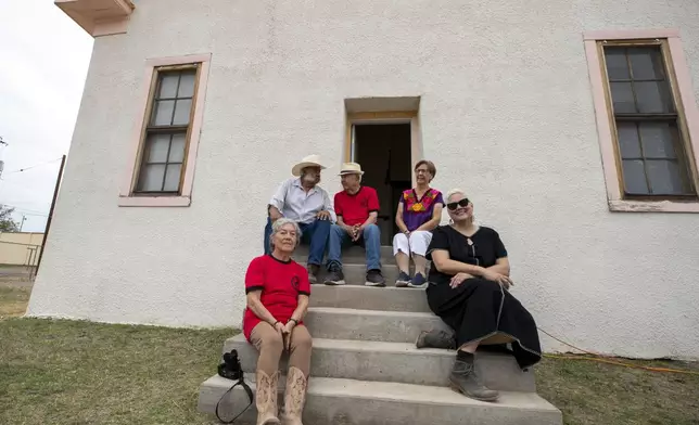 From left, alumni Betty Nuñez Aguirre, musician Remigio "Primo" Carrasco, alumni Ismael Vasquez, his wife Elisa Vasquez and Gretel Enck, former president of the Blackwell School Alliance, sit at the school entrance during its inauguration as the newest National Historic Site in Marfa, Texas, Saturday, Sept. 14, 2024. (AP Photo/Andres Leighton)