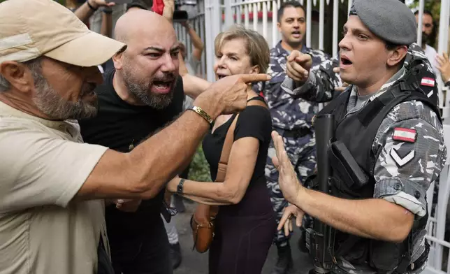 A Lebanese police officer blocks protesters from entering the court building, as they protest against Riad Salameh, the former governor of Lebanon's Central Bank, in Beirut, Lebanon, Monday, Sept. 9, 2024. (AP Photo/Hussein Malla)