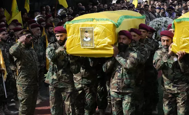 Hezbollah members carry the coffins of two of their comrades who were killed on Wednesday when a handheld device exploded, during a funeral procession in the southern suburbs of Beirut, Thursday, Sept. 19, 2024. (AP Photo/Hussein Malla)