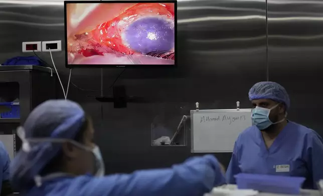 A damaged eye of a man who was injured in one of the handheld exploding devices is seen through a screen, inside an operation room during an eye surgery at the Eye Specialist hospital, in Beirut, Lebanon, Friday, Sept. 20, 2024. (AP Photo/Hussein Malla)