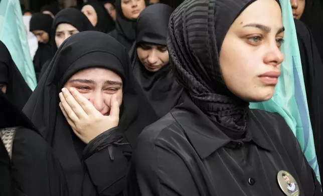 A girl cries during the funeral procession of two Hezbollah members, killed on Wednesday when a handheld device exploded, in the southern suburbs of Beirut, Thursday, Sept. 19, 2024. (AP Photo/Hussein Malla)