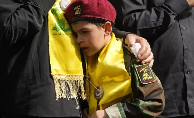 A boy cries during the funeral procession of two Hezbollah members in the southern suburbs of Beirut, Thursday, Sept. 19, 2024. (AP Photo/Hussein Malla)