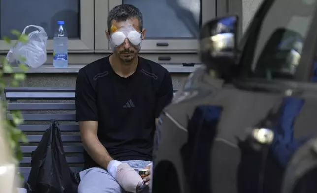 A man who was injured in one of the handheld exploding devices, sits outside a hospital as he waits for treatment in Beirut, Lebanon, Friday, Sept. 20, 2024. (AP Photo/Hussein Malla)