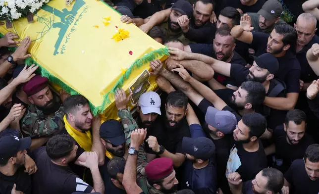 Hezbollah members carry the coffin of their comrade who was killed on Wednesday when a handheld device exploded, during a funeral procession in the southern suburbs of Beirut, Thursday, Sept. 19, 2024. (AP Photo/Hussein Malla)