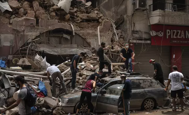 FILE - People remove debris from a house damaged by a massive explosion in the seaport of Beirut, on Aug. 7, 2020. (AP Photo/Felipe Dana, File)