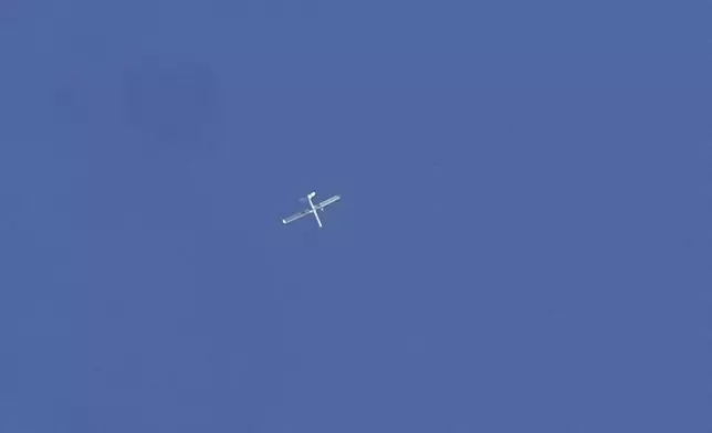 FILE - An Israeli reconnaissance drone flies over the funeral procession of four Hezbollah fighters who were killed Tuesday after their handheld devices exploded in the southern suburb of Beirut, Wednesday, Sept. 18, 2024. (AP Photo/Bilal Hussein, File)