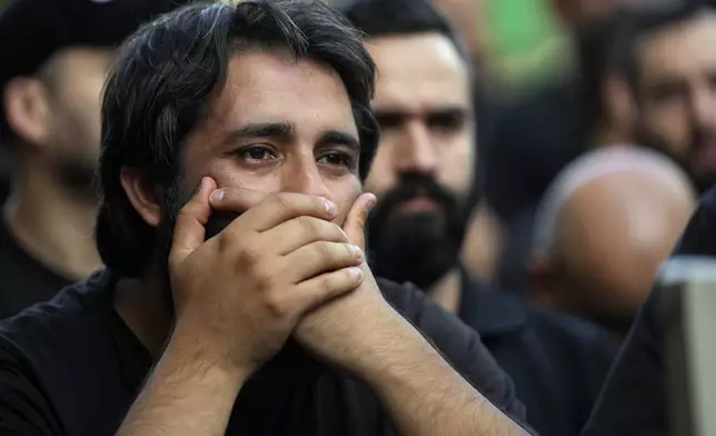 A man mourns during the funeral procession of two Hezbollah members, killed on Wednesday when a handheld device exploded, in the southern suburbs of Beirut, Thursday, Sept. 19, 2024. (AP Photo/Hussein Malla)