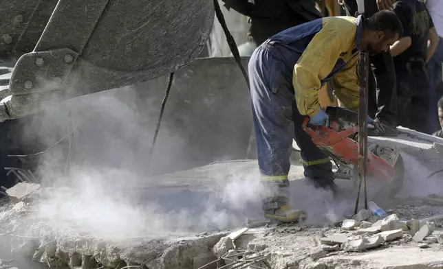 An emergency worker cuts concrete blocks as he searches for survivors at the scene of an Israeli airstrike in the town of Maisara, north of Beirut, Wednesday, Sept. 25, 2024. (AP Photo/Bilal Hussein)