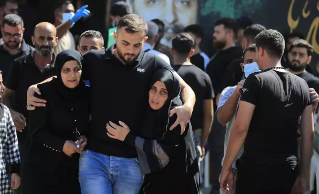 People react during the funeral procession of their relatives, who were killed in Monday's Israeli airstrikes, in the southern village of Saksakieh, Lebanon, Tuesday, Sept. 24, 2024. (AP Photo/Mohammed Zaatari)