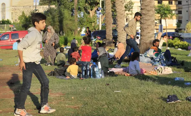 Lebanese citizens who fled the southern villages amid ongoing Israeli airstrikes Monday, settle at a public park in the southern port city of Sidon, Lebanon, Tuesday, Sept. 24, 2024. (AP Photo/Mohammed Zaatari)