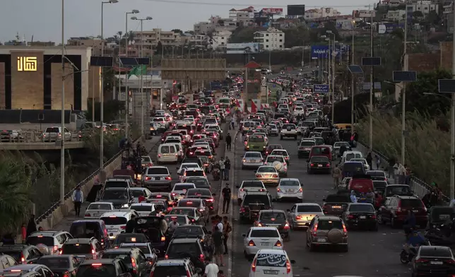 People who fled the southern villages amid ongoing Israeli airstrikes Monday, sit in their cars as they are stuck in traffic at a highway that links to Beirut city, in the southern port city of Sidon, Lebanon, Tuesday, Sept. 24, 2024. (AP Photo/Mohammed Zaatari)