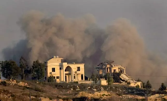 Smoke rises behind a destroyed house following an Israeli airstrike on Khiam village, as seen from Marjayoun town, south Lebanon, Tuesday, Sept. 24, 2024. (AP Photo/Hussein Malla)