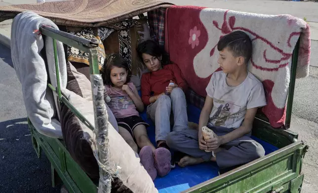 Children sit in a motorcycle cart in Beirut's Martyrs' square after fleeing the Israeli airstrikes in the southern suburbs of Dahiyeh, Sunday, Sept. 29, 2024. (AP Photo/Bilal Hussein)