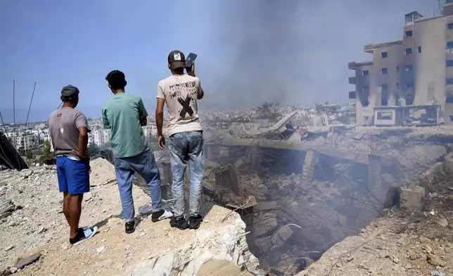 People check a damaged building at the site of an Israeli airstrike in Choueifat, south east of Beirut, Saturday, Sept. 28, 2024. (AP Photo/Hussein Malla)