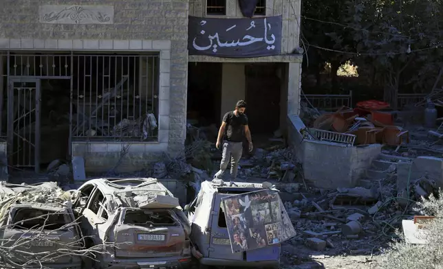 A man stands on top of a damaged car at the site of an Israeli airstrike in Saksakieh, south Lebanon, Thursday, Sept. 26, 2024. (AP Photo/Mohammed Zaatari)