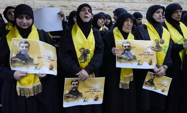 Mourners react as they attend the funeral procession of Hezbollah commanders Ibrahim Kobeisi and Hussein Ezzedine, pictured, in Beirut's southern suburb, Wednesday, Sept. 25, 2024. (AP Photo/Hassan Ammar)