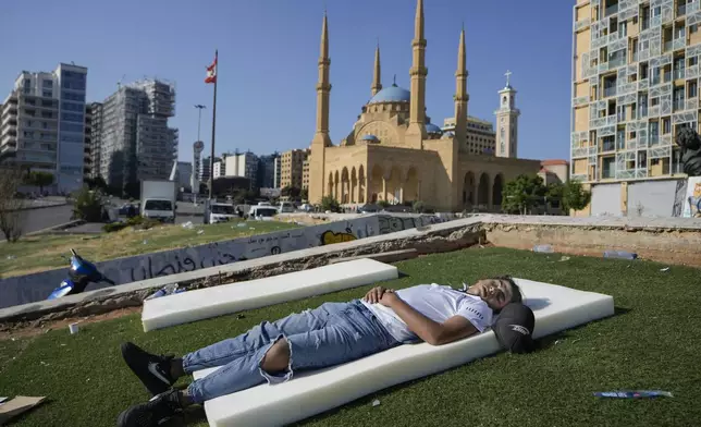 A boy sleeps in Beirut's Martyrs' square after fleeing the Israeli airstrikes in the southern suburbs of Dahiyeh, Sunday, Sept. 29, 2024. (AP Photo/Bilal Hussein)