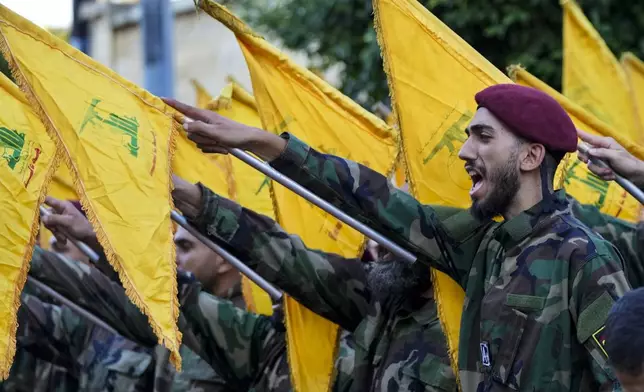 Hezbollah members raise their group flags and chant slogans as they attend the funeral procession of Hezbollah commanders Ibrahim Kobeisi and Hussein Ezzedine in Beirut's southern suburb, Wednesday, Sept. 25, 2024. (AP Photo/Hassan Ammar)