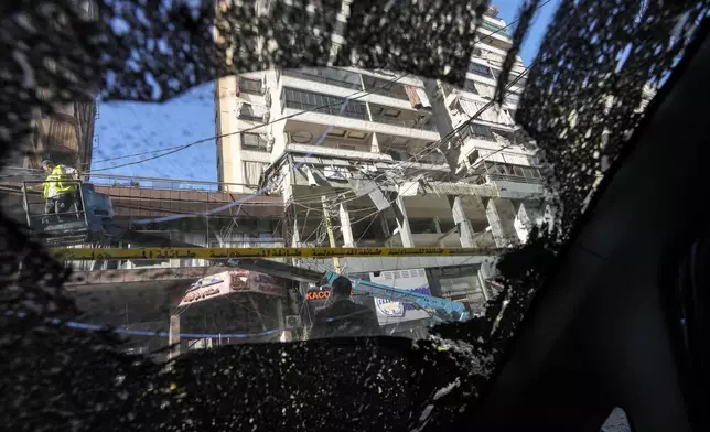 The damaged building at the site of an Israeli airstrike, seen from the shattered window of a car, in Beirut's southern suburb, Thursday, Sept. 26, 2024. (AP Photo/Hassan Ammar)