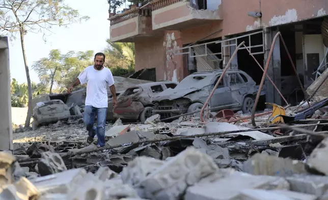 A man checks the damage to a building hit in an Israeli airstrike in the southern village of Akbieh, Lebanon, Tuesday, Sept. 24, 2024. (AP Photo/Mohammed Zaatari)