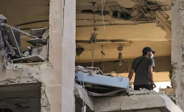 A resident checks an apartment that was hit by an Israeli airstrike in Beirut's southern suburbs, Thursday, Sept. 26, 2024. (AP Photo/Hassan Ammar)