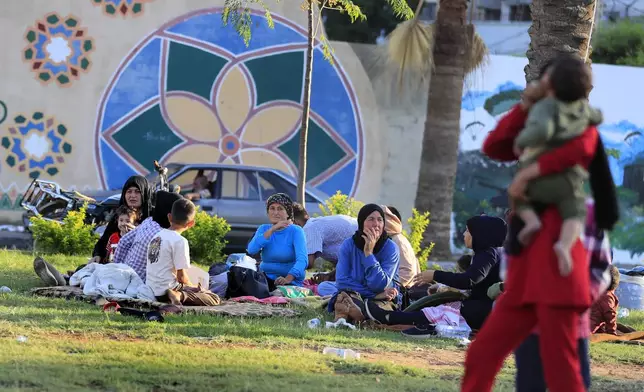 Lebanese citizens who fled the southern villages amid ongoing Israeli airstrikes Monday, sit at a park in the southern port city of Sidon, Lebanon, Tuesday, Sept. 24, 2024. (AP Photo/Mohammed Zaatari)