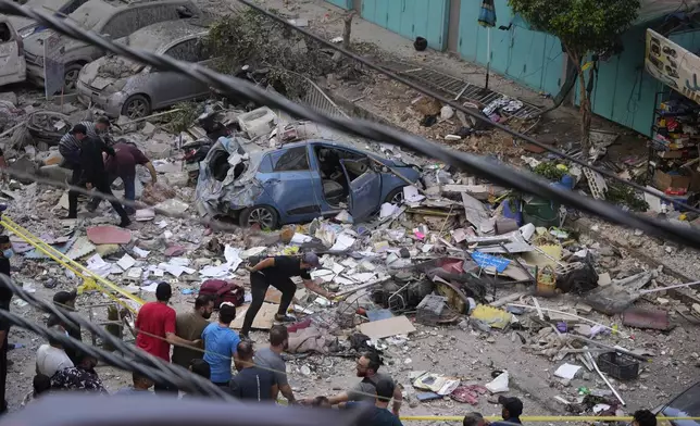 Residents check the site of an Israeli airstrike in Beirut's southern suburbs, Tuesday, Sept. 24, 2024. (AP Photo/Hassan Ammar)