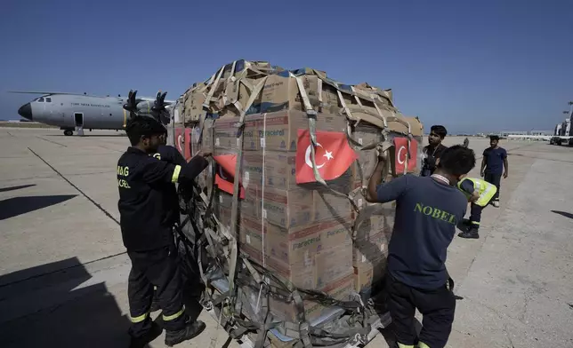 Workers unload Turkish medical aid boxes arriving at Beirut International airport, Wednesday, Sept. 25, 2024. (AP Photo/Bilal Hussein)