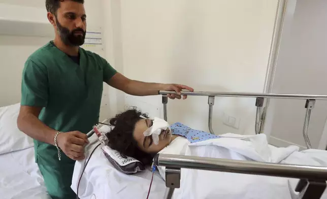 Fatima Abdel Rahman Zorout, 7, who was wounded in an Israeli airstrike, is wheeled on a gurney at the Alaaeddine Hospital in Sarafand, south Lebanon, Thursday, Sept. 26, 2024. (AP Photo/Mohammed Zaatari)