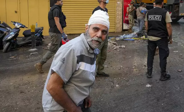 A wounded man reacts at the scene of the building that was hit by an Israeli airstrike in Beirut's southern suburbs, Tuesday, Sept. 24, 2024. (AP Photo/Hassan Ammar)