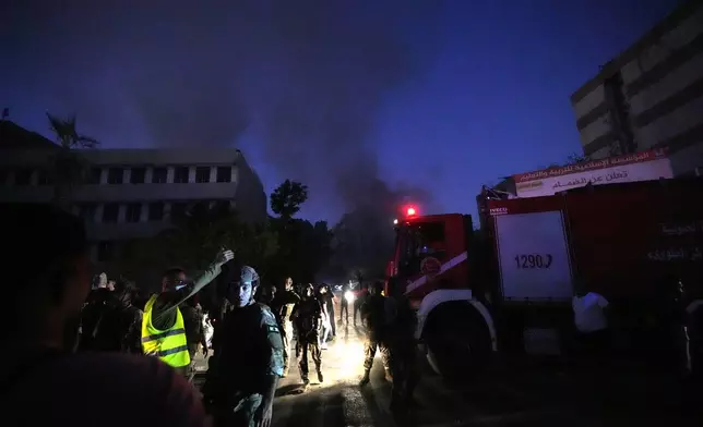 Rescuers arrive near the site of an Israeli airstrike in Beirut's southern suburbs, Friday, Sept. 27, 2024. (AP Photo/Hassan Ammar)