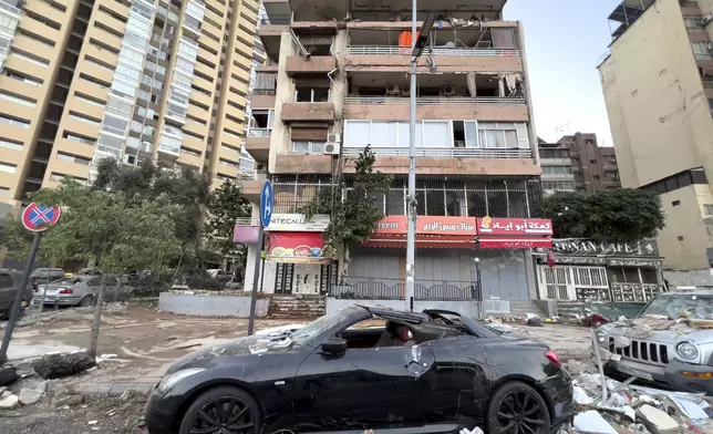 Damaged cars are parked in front of a building that was hit by an Israeli airstrike early Monday, Sept. 30, 2024, in Beirut, Lebanon. (AP Photo/Hussein Malla)