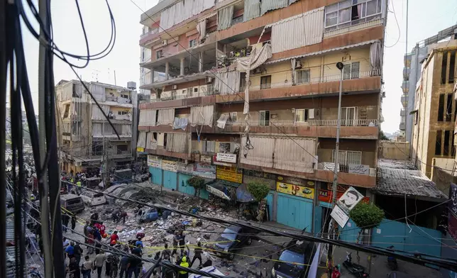 Residents and rescuers check a building that was hit by an Israeli airstrike in Beirut's southern suburbs, Tuesday, Sept. 24, 2024. (AP Photo/Hassan Ammar)