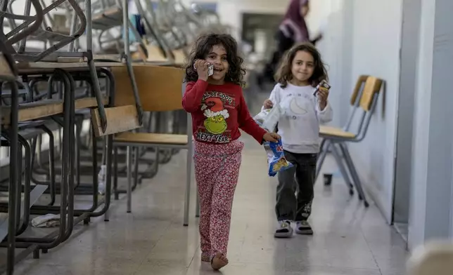 Displaced children play in a classroom at a school, in Beirut, after fleeing the Israeli airstrikes in the south with their families, Thursday, Sept. 26, 2024. (AP Photo/Bilal Hussein)