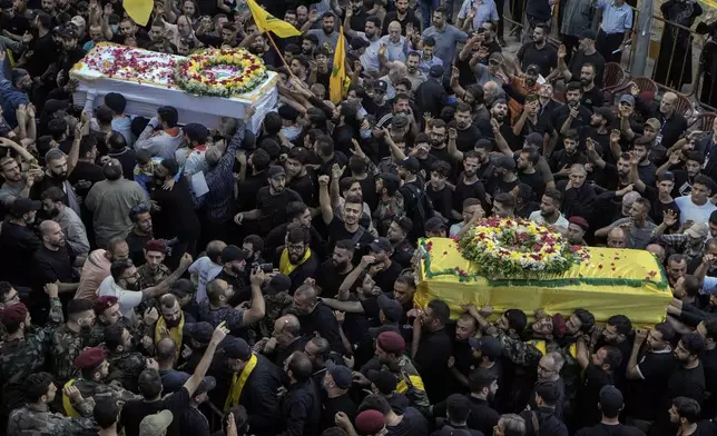 Mourners carry the coffins of victims who were killed Tuesday after their handheld pagers exploded, during their funeral procession in the southern suburb of Beirut, Lebanon, Wednesday, Sept. 18, 2024. (AP Photo/Bilal Hussein)