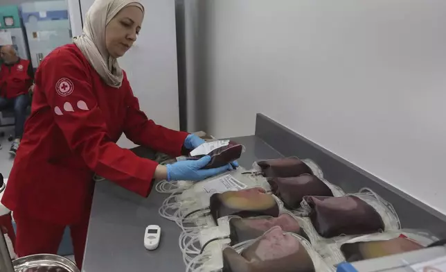 A Lebanese Red Cross volunteer collects blood donations for those who were injured by their exploded handheld pagers, Tuesday, Sept. 17, 2024, at a Red Cross center in the southern port city of Sidon, Lebanon. (AP Photo/Mohammed Zaatari)