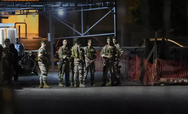 Lebanese soldiers stand guard as their comrades prepare to detonate a walkie-talkie that was found at the parking of the American University Hospital, in Beirut, Lebanon, Wednesday, Sept. 18, 2024. (AP Photo/Hassan Ammar)