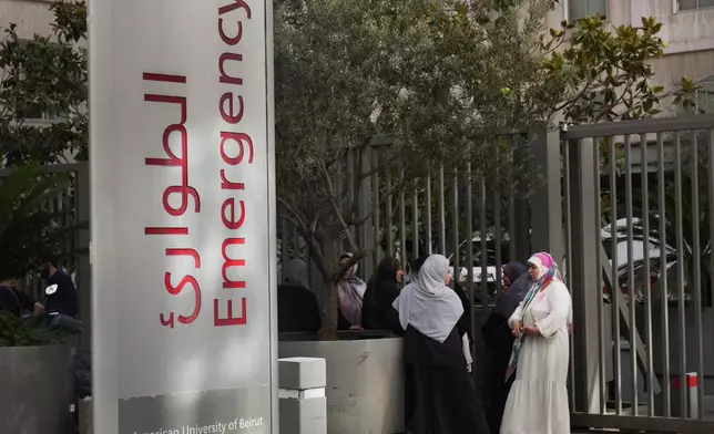 Families of victims who were injured on Monday by their exploding handheld pagers, wait at the emergency entrance of the American University hospital, in Beirut, Lebanon, Wednesday, Sept. 18, 2024. (AP Photo/Hussein Malla)