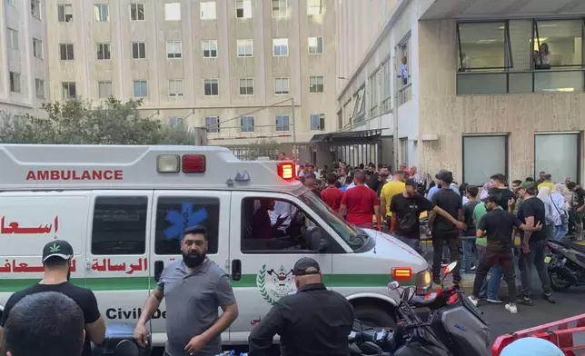 People gather outside the American University hospital after the arrival of several men who were wounded by exploded handheld pagers, in Beirut, Lebanon, Tuesday, Sept. 17, 2024. (AP Photo/Bassam Masri)