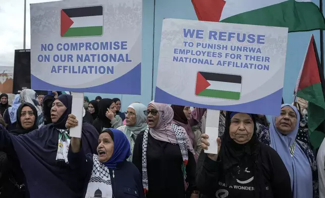 Palestinians in Lebanon hold placards during a protest in front of the United Nations Relief and Works Agency (UNRWA) headquarters in Beirut, Lebanon, Tuesday, Sept. 17, 2024. (AP Photo/Bilal Hussein)