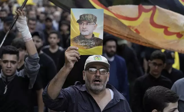 Hezbollah supporters carry pictures of Hezbollah commander Ibrahim Akil during his funeral procession in Beirut's southern suburb, Sunday, Sept. 22, 2024. (AP Photo/Bilal Hussein)