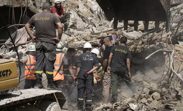 Emergency workers clear the rubble at the site of Friday's Israeli strike in Beirut's southern suburbs, Saturday, Sept. 21, 2024. (AP Photo/Bilal Hussein)