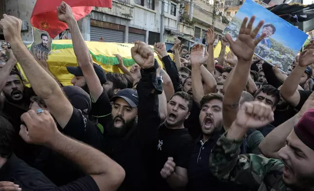 Mourners chant slogans as they carry the coffins of Hezbollah fighters who were killed in Friday's Israeli strike, during their funeral procession in the southern suburb of Beirut, Lebanon, Saturday, Sept. 21, 2024. (AP Photo/Bilal Hussein)